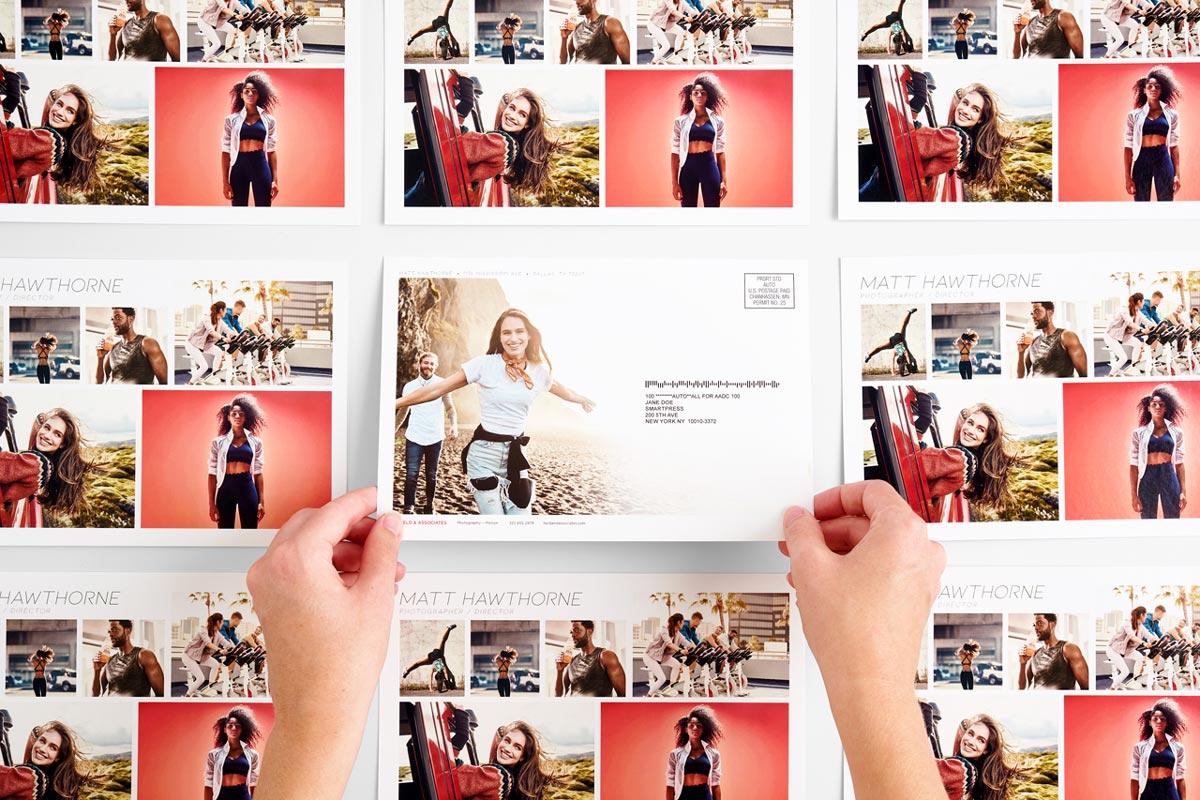Six direct mail postcards lined up in rows with two hands holding the one in the middle.